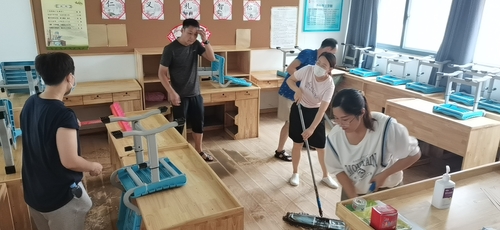 志愿者们打扫被淹教室